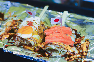Japanese-style crepes with toppings, sauce, and small flags.