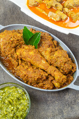 rendang ayam padang, rendang is one of West Sumatra delicious meat based dishes, served on a gray plate.