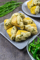 Tahu aci khas tegal served on a grey plate, snack made from tofu that is split, then filled with tapioca flour mixture, chives leaves, and other spices before being fried. indonesia food