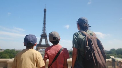 Family sightseeing the eiffel tower from a parisian street, parents and children enjoying a summer city break, strolling and discovering the iconic landmark together