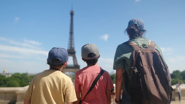 Family sightseeing the eiffel tower from a parisian street, parents and children enjoying a summer city break, strolling and discovering the iconic landmark together