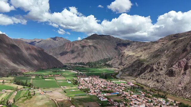Vertical camera movement showcasing the transition from the Yucay town center to the surrounding agricultural fields and mountains