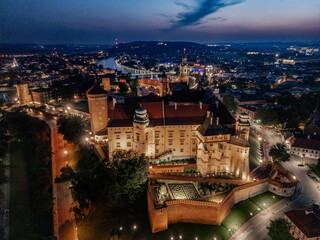 Aerial evening view of Wawel Castle in Krak&oacute;w, Poland, with illuminated walls and Vistula River