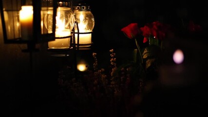 Person placing a burning candle on a grave at a quiet cemetery, soft warm light illuminating the tombstone and creating an emotional moment of remembrance and mourning, captured in 4K ultra HD.