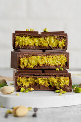 Dubai chocolate with kadayif dough and pistachio paste. Trend dessert on a board on a concrete...