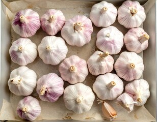 Top view of garlic cloves arranged closely on a tray, showcasing natural texture and organic detail in a simple, rustic food presentation.