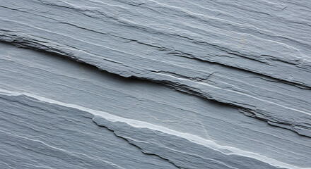 A close up shot of a gray slate stone texture with diagonal lines and rough edges in a natural setting