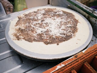 Process of making Kue Leker or Indonesian crepes with chocolate and cheese toppings