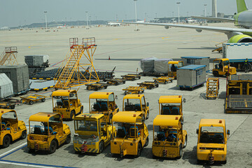 Multiple aircraft pushback tractors and ground support vehicles parked on the tarmac at an airport, ready for aircraft towing and ground operations.