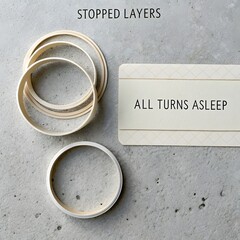 Abstract layered paper rings and card on grainy concrete