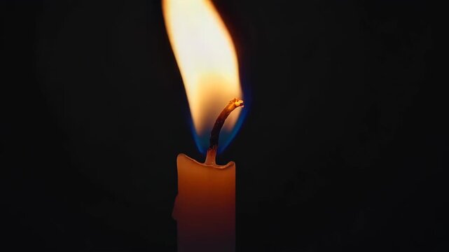 Tranquil candle flame dancing in darkness: capturing serenity and warmth in motion