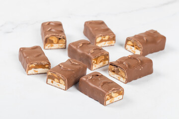 Chocolate peanut bar. With nougat and caramel. White background. Close up	