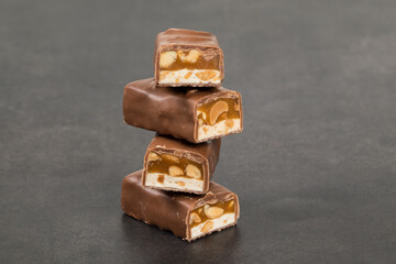 Chocolate peanut bar. With nougat and caramel. Dark background