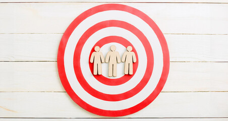 Three Wooden Human Figures on Red and White Target Circle Symbolizing Audience Focus