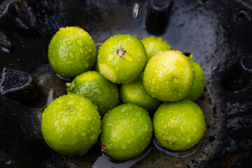 Fresh Green Limes with Water Droplets in a Rustic Setting