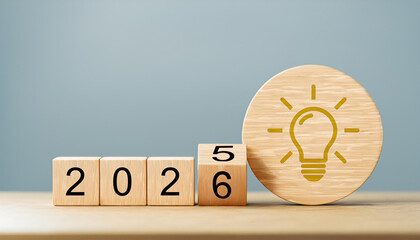 Yellow Lightbulb Idea Icon with Year Transition from 2025 to 2026 on Wooden Cubes