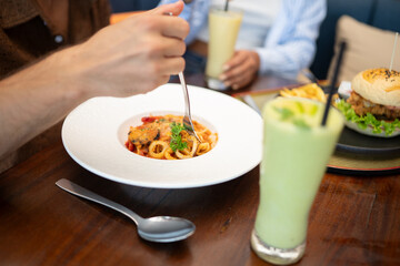 A variety of dishes and drinks are displayed on a restaurant table. Travel, food and happiness