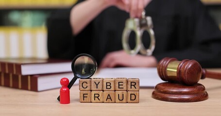 Exploring the consequences of cyber fraud in a courtroom setting with a judge's gavel and handcuffs