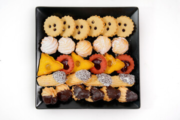 Assorted holiday cookies on black platter top view