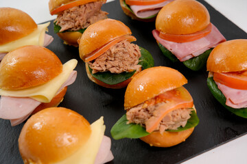 Party sliders and mini sandwiches serving appetizers on slate
