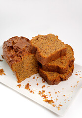 Homemade carrot bread loaf with slices on white plate