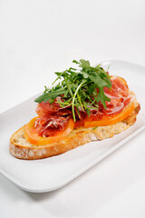 Bruschetta topping prosciutto, tomato, and arugula on toast
