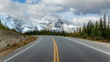 Scenic road toward snowy peaks on Icefields Parkway in Alberta