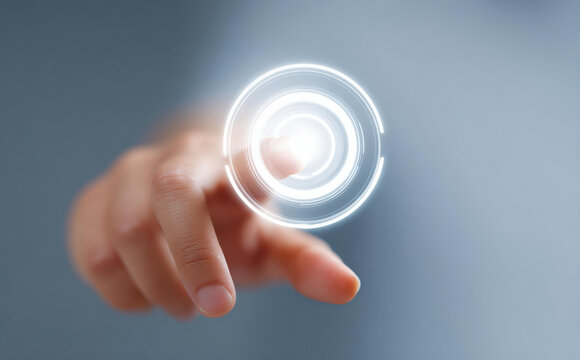 Person finger showing focus while about to touch glowing futuristic circle button. An innovative technology concept for digital interface and network connection