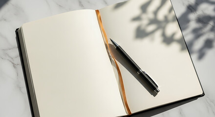 Blank open notebook with pen on white marble background and plant shadows