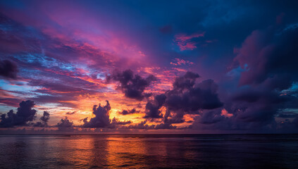 A tropical sea view glows with colorful light as the sun sinks below distant islands. The water shimmers gently under a dramatic painted sky.