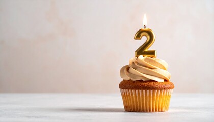 Golden numeral two candle burning brightly atop a delicious cupcake with fluffy frosting, celebrating a special occasion