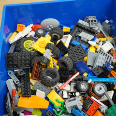 Naklejka premium Colorful assortment of toy building blocks in a blue storage container