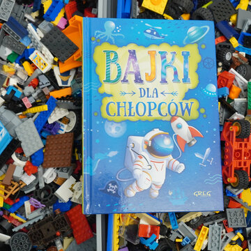 Children's book with astronaut and rocket on a background of colorful toy bricks
