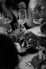 Hand with a glass of wine in the night atmosphere of the restaurant