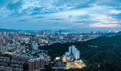 Obraz premium Sprawling urban residential area mixed with green hills at dusk in Shenzhen.
