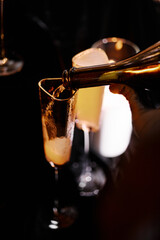 The waiter pours champagne into glasses before the celebration