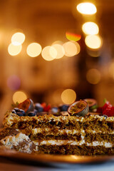 Slice of delicious cake showing layers of cream filling and sponge cake topped with pink and white frosting