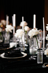 Luxurious setting of dark restaurant tables with candles and fresh flowers
