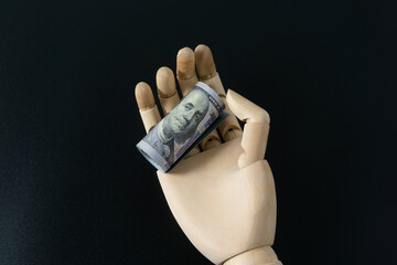 Wooden hand model and dollar banknote