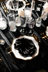 Luxurious setting of dark restaurant tables with candles and fresh flowers