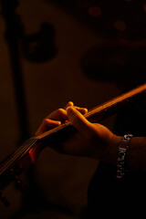 Close up look of a man playing the electric guitar during a concert, no faces are shown, shallow depth of field
