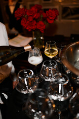 A waiter pours wine in a restaurant in the evening