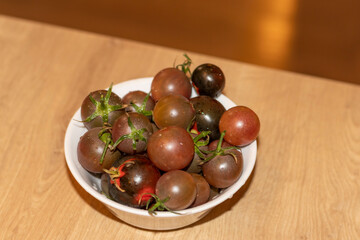 Dark cherry tomatoes in the bowl. Food