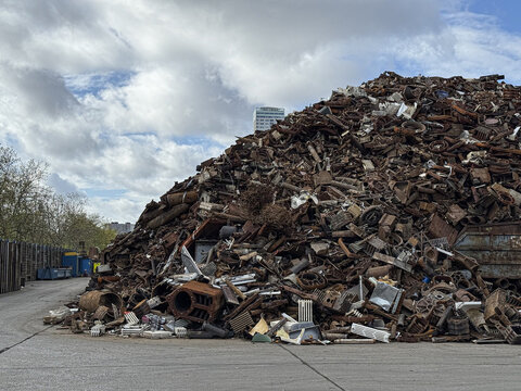 Large pile of scrap metal awaiting recycling under cloudy sky
