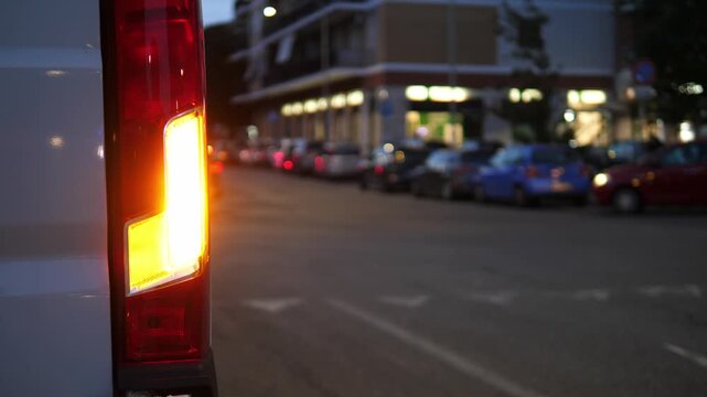Rear blinker flashes on parked van at night in no-parking zone