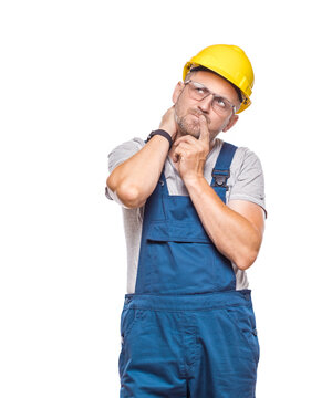 Pensive middle-aged construction worker being in confusion with arms on head, isolated on white background. Thoughtful repairman planing something. Craftsman against white wall
