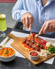 Meat on flatbread with sides and drink at restaurant table setting close up view