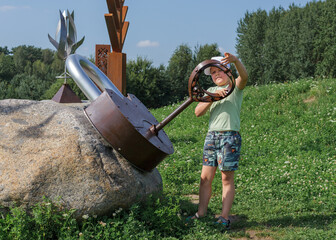 A little boy is playing in the park and locking a large metal padlock