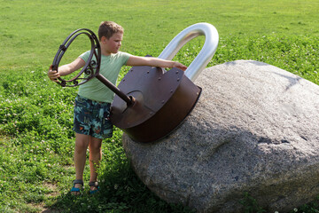 Little boy examines a gigantic lock with a large metal key on the playground