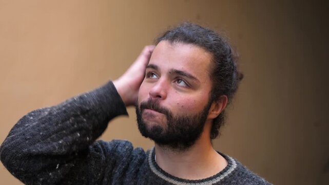 Young man scratching head